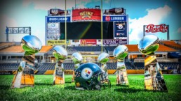 Steelers helmet and trophies on field.