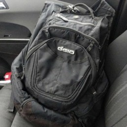 OGIO consumer customer Kristy and her son share backpack shot in truck in passenger seat against grey